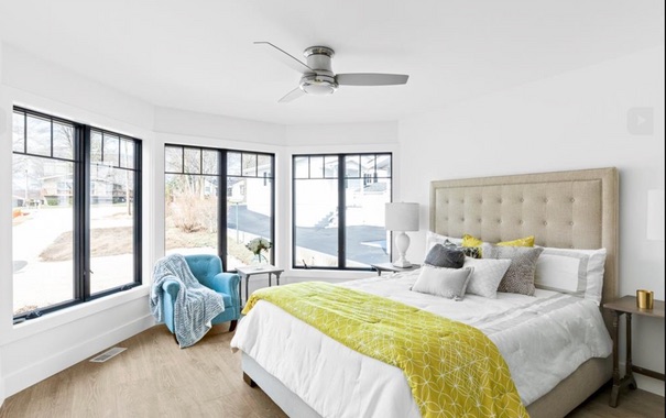 Lake house bedroom with black windows and yellow accents