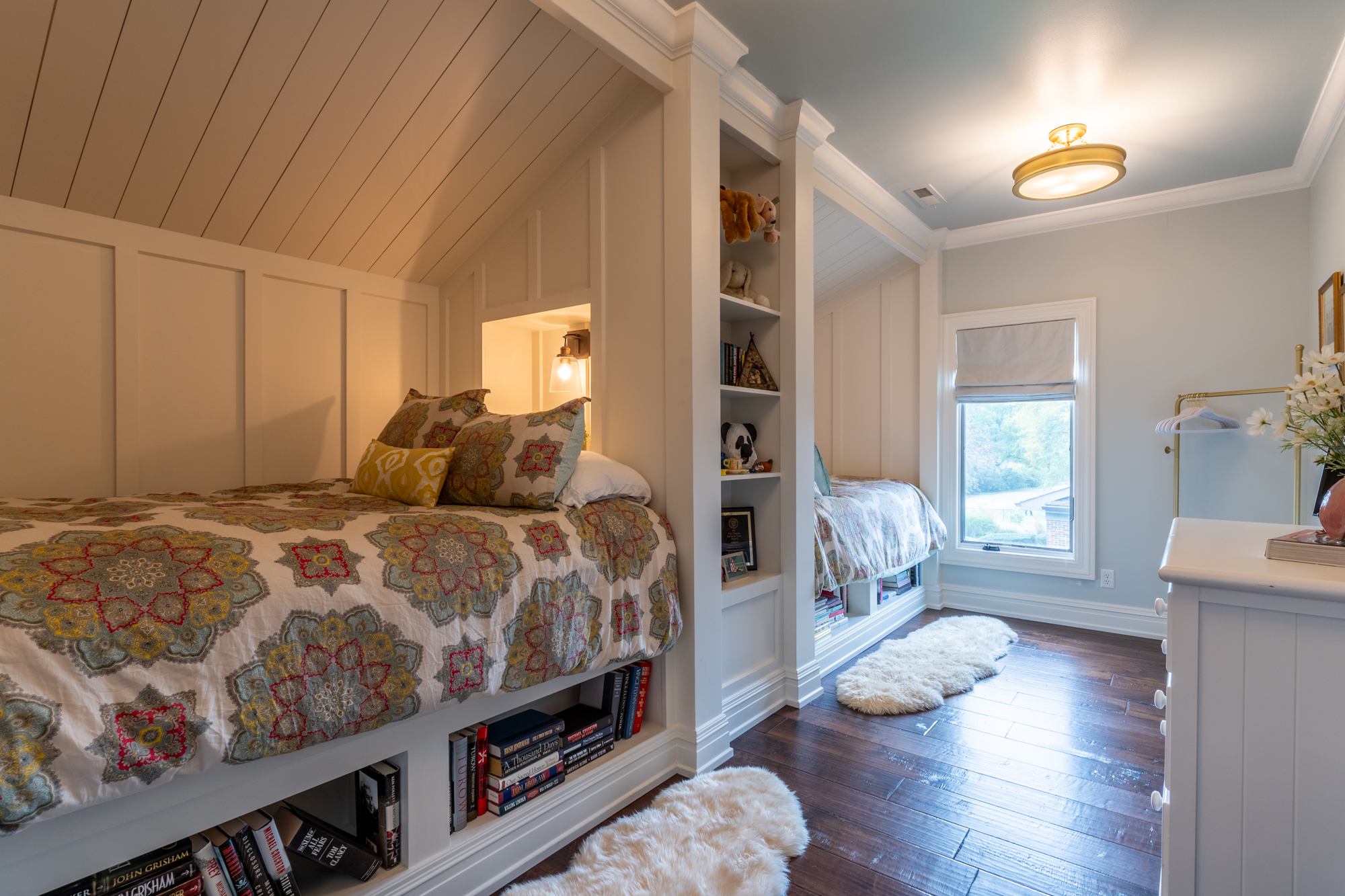 Guest room with built-in beds, book storage and soft blue ceiling detail