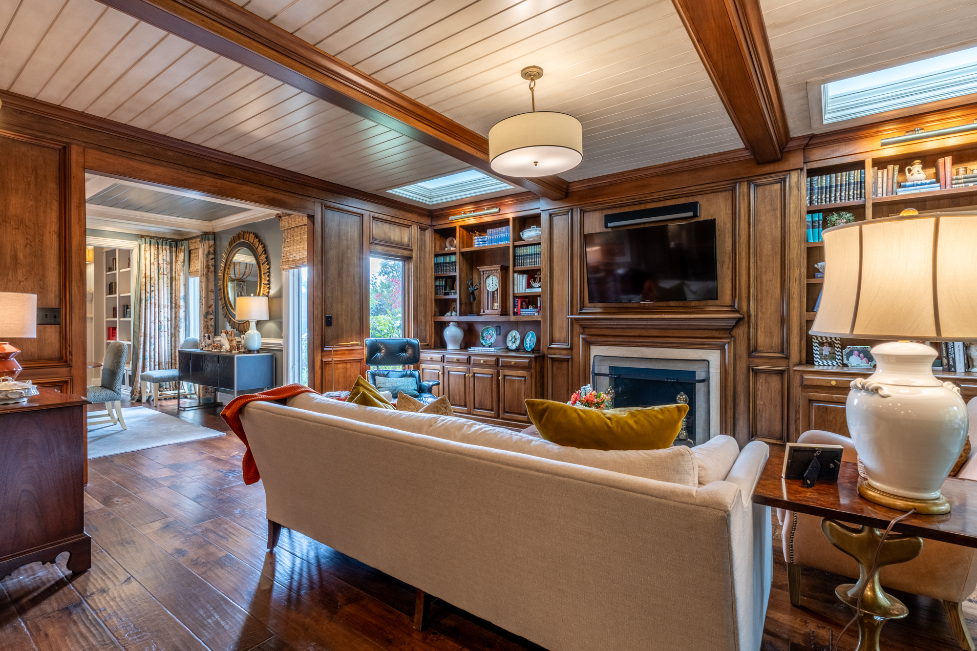 Warm wood-paneled library with custom cabinetry and layered furnishings