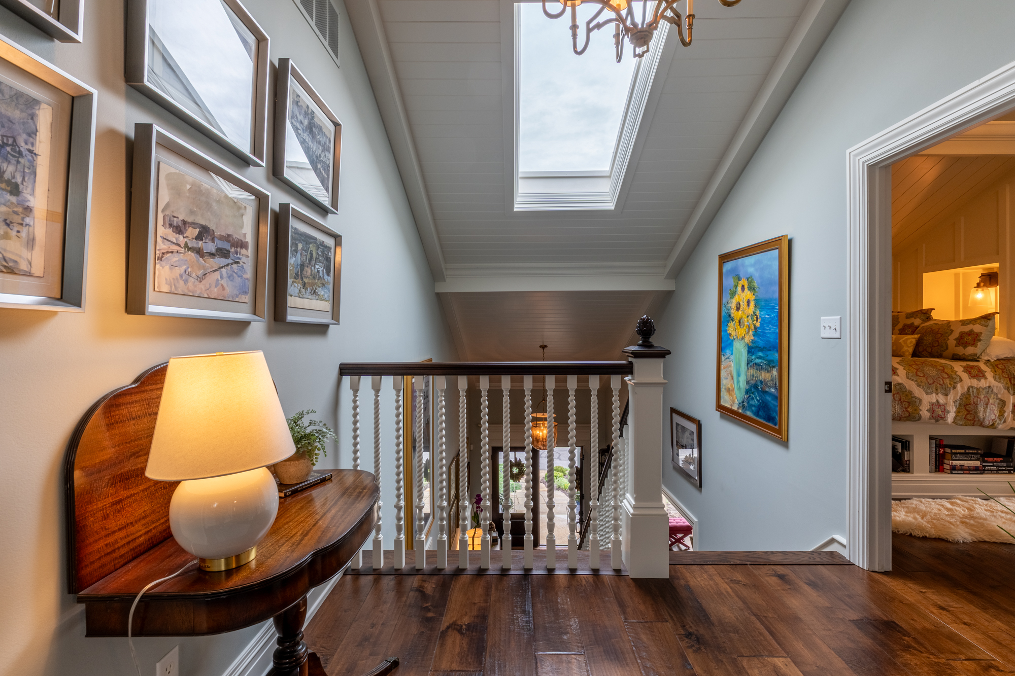 Upstairs gallery at Mallard Cove with art, skylights and a view into the guest room
